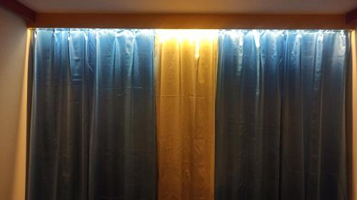 达卡Signature Home的窗户,窗户上挂着窗帘,阳光照耀着