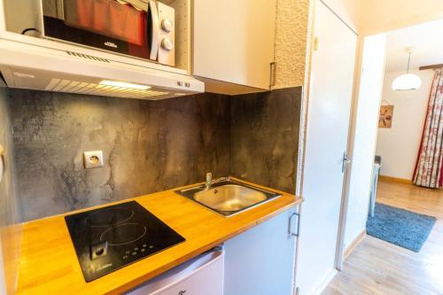 莱索尔Résidence Le 1650 - Studio 834的厨房配有水槽和微波炉