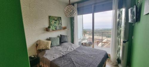 卡斯特利翁-德拉普拉纳Peñiscola - Casa Mirador mit Gemeinschaftspool的一间卧室设有一张床,享有阳台的景色