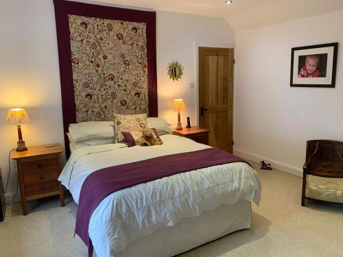 TettenhallStable Cottage的一间卧室配有一张大床、两张桌子和两盏灯。