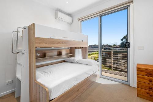 墨尔本Nice & Quiet 2-Bed by Shops & Airport的一间卧室设有一张双层床和大窗户。