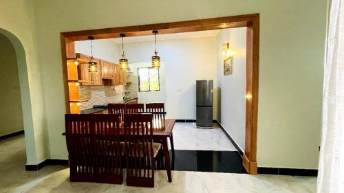 Boma la NgombeSafi House的用餐室以及带桌椅的厨房。