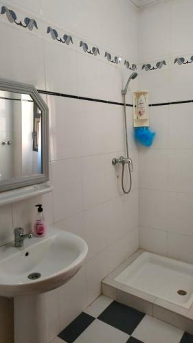 乌季达Logement calme très proche du centre的白色的浴室设有水槽和淋浴。