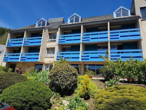 蒂耶扎克Le Castel du Cantal Groupe Village Fani的大型公寓楼设有蓝色阳台