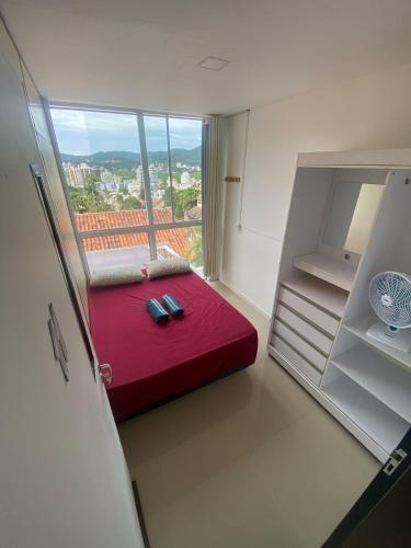 弗洛里亚诺波利斯Hospedaria Trindade的客房设有红色的床和开放式冰箱。
