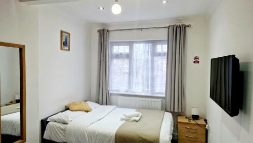 WansteadPeaceful & Private 2-Bedroom Suite - A London Gem的一间小卧室,配有床和窗户