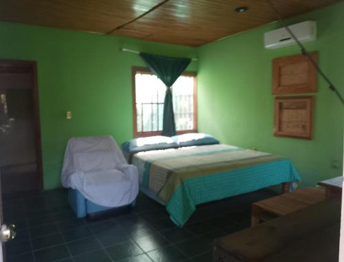 Tuxtla ChicoHotel El Dorado的绿色卧室设有床和窗户