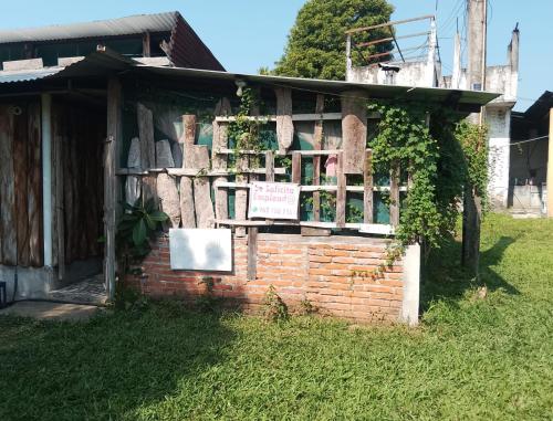Tuxtla ChicoHotel El Dorado的草上带有标志的砖砌建筑