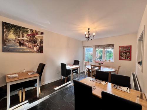 贝尔法斯特Ashfield Bed & Breakfast的用餐室配有桌椅,墙上挂有绘画作品