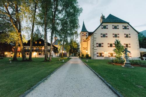 滨湖采尔Schloss Prielau Hotel & Restaurants的通往白色大建筑的车道