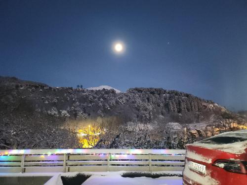 卑尔根Fjordclaw SNM- adjoining the Bergen city & Nature的雪覆盖的山,天空中满月