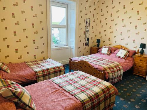 蒙特罗斯The Limes Guest House的一间卧室设有两张床和窗户。
