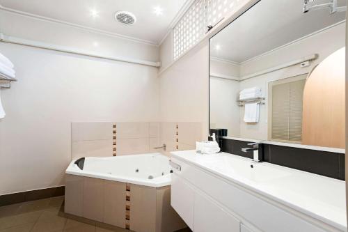 莱克斯恩特伦斯Comfort Inn & Suites Lakes Entrance的带浴缸、水槽和镜子的浴室