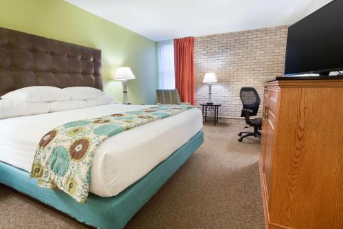 麦卡伦Drury Inn & Suites McAllen的配有一张床和一台平面电视的酒店客房