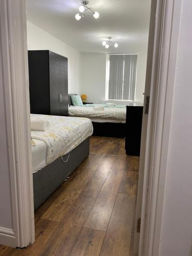 曼彻斯特卢施尔梅旅馆的一间卧室设有两张床,铺有木地板