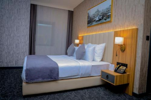 吉布提Best Western Premier DJ Hotel的酒店客房设有一张大床和电话