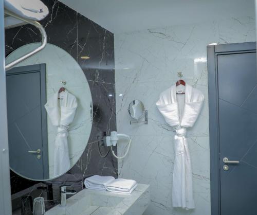 吉布提Best Western Premier DJ Hotel的浴室设有镜子和墙上的浴袍