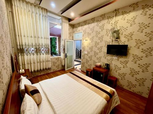 波来古市HOTEL MINH LÂM 2的一间卧室设有一张床、一个窗口和一台电视