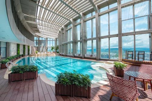 三亚三亚中心凯悦嘉轩酒店（网红空中泳池打卡）的一座大型游泳池,位于一座带窗户的建筑内