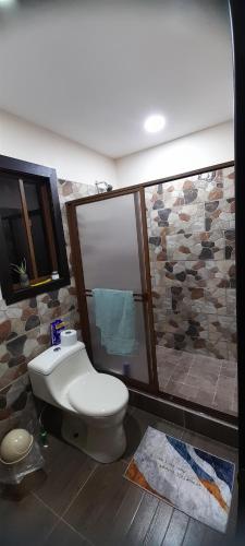 昆卡Rancho Valle del Rio的一间带卫生间和石墙的浴室