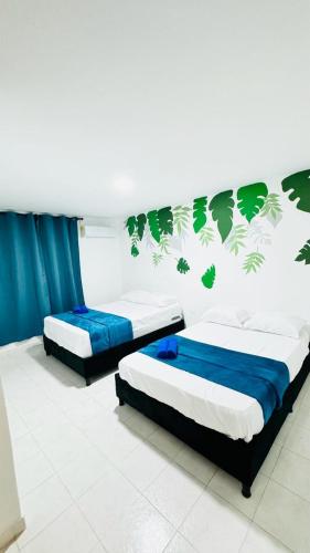 卡塔赫纳Marbar Cartagena Hostel的配有两张蓝色和绿色壁纸的客房