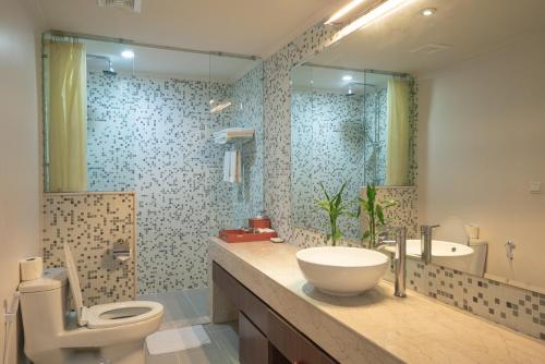 金边中央大厦服务式公寓的一间带水槽、卫生间和镜子的浴室
