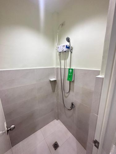 麦克坦Travelbee Airport Inn的浴室里设有淋浴,墙上有绿色的标志