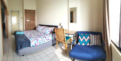 波德申Seafront Corus Resort Port Dickson的一间卧室配有一张床、一张桌子和一把椅子