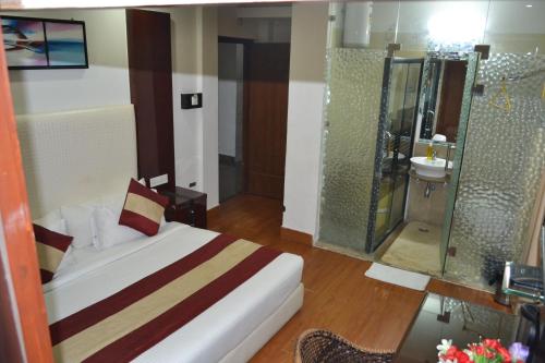 哈里瓦格娜伊思提卡酒店的酒店客房配有一张床和淋浴