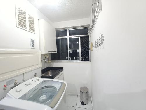里约热内卢Apê UNIFA-EsSLog Condomínio com estacionamento的白色的浴室设有水槽和窗户。