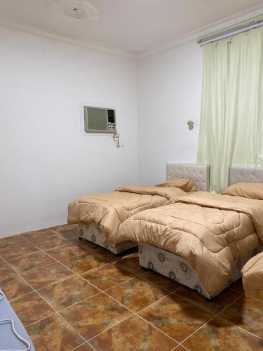 Sīdī Ḩamzahالعلم نور2的一间卧室设有两张床和篮球架