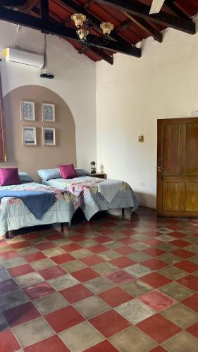 SuchitotoDonde Polo Hostal的一间卧室设有两张床,铺有一个 ⁇ 板地板