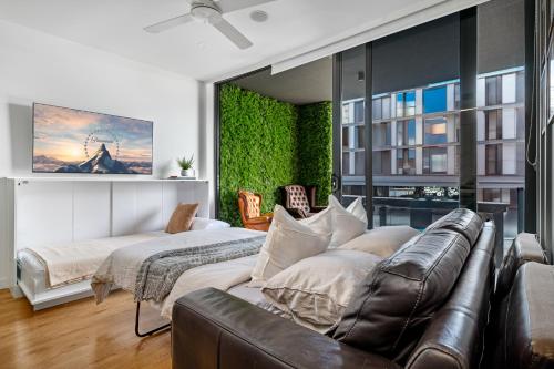 布里斯班Brisbane Luxury Gabba Apartment的一间配有沙发的卧室和一张位于客房内的床
