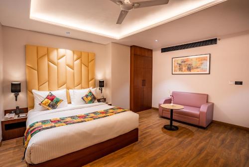 阿格拉Regenta Place Raaj Agra的一间卧室配有一张大床和一把椅子