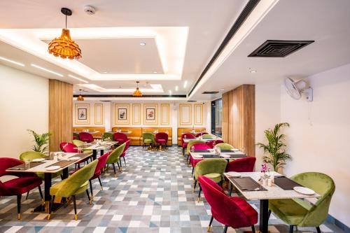 阿格拉Regenta Place Raaj Agra的一间在房间内配有桌椅的餐厅