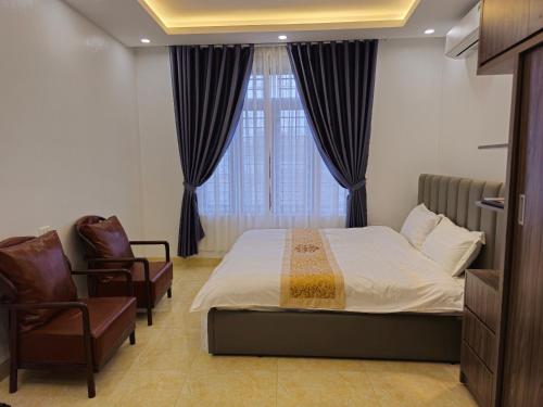 Làng Trang4L HOTEL KIM BÔI的卧室配有床、椅子和窗户。