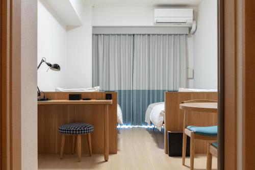 大阪yksi STAY ＆ APARTMENT OSAKA的一间医院间,配有一张床和一张桌子及椅子