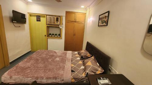 孟买Home sweet home 3BHK的一间小卧室,配有一张床和一张桌子