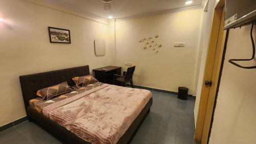 孟买Home sweet home 3BHK的一间卧室配有一张床和一张桌子