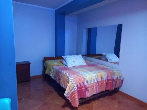 万卡约Hospedaje TOSCANO SUITES的蓝色客房中一间带床的卧室