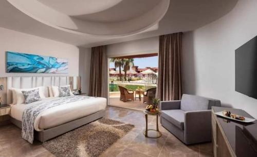 赫尔格达Hawaii hotels & blend club resort&sea jul&的一间卧室配有一张床、一张沙发和一张桌子