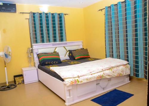 Suberu OjeRehoboth hotel, Apartment and Event services的一间卧室配有白色的床和蓝色窗帘