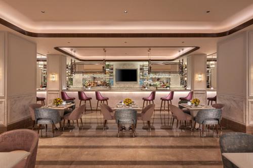 孟买Aurika, Mumbai Skycity - Luxury by Lemon Tree Hotels的一间带桌椅的餐厅和一间酒吧
