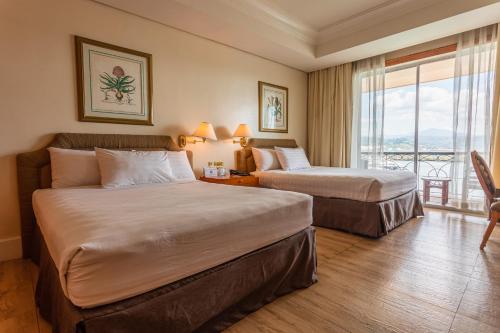 奥隆阿波The Subic Bay Yacht Club, Inc.的酒店客房设有两张床和一个阳台。
