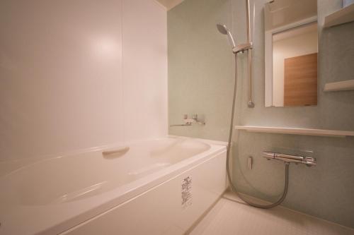 小樽Ryoan / Vacation STAY 80251的白色的浴室设有浴缸和淋浴。