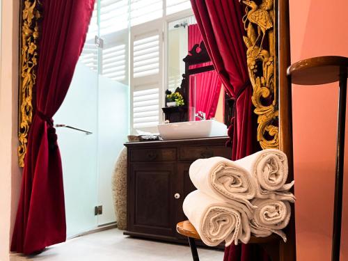 乔治市Peranakan Suites Georgetown的一间设有镜子和毛巾的椅子的房间