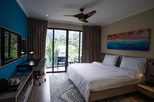 博瓦隆Thalassa Seychelles的一间带大床的卧室和一个阳台