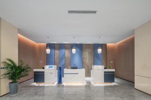 巴中巴中中心智选假日酒店的拥有蓝色和棕色墙壁和书桌的办公大堂