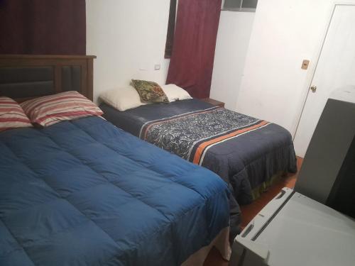 维纳德马Hostal batuco的一间设有两张床和椅子的房间