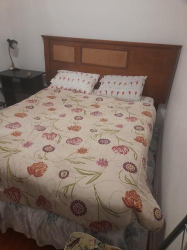 维纳德马Hostal batuco的一张带花卉床罩和枕头的床